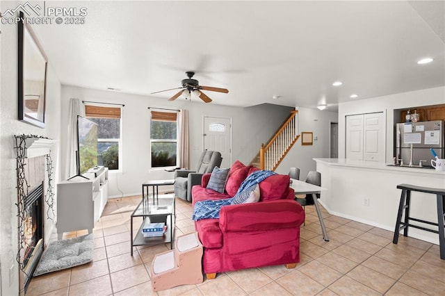 living area with recessed lighting, a fireplace, light tile patterned floors, baseboards, and stairs