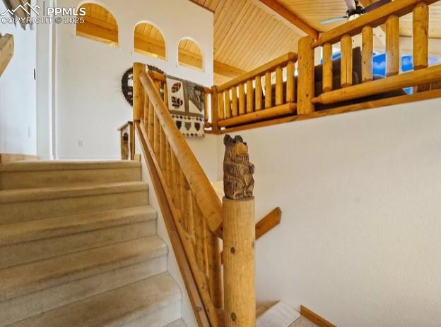 stairs featuring wooden ceiling, ceiling fan, and vaulted ceiling with beams