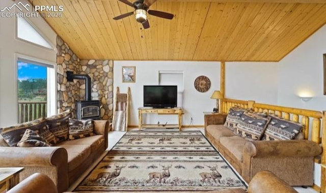 living room with ceiling fan, wooden ceiling, a wood stove, and vaulted ceiling