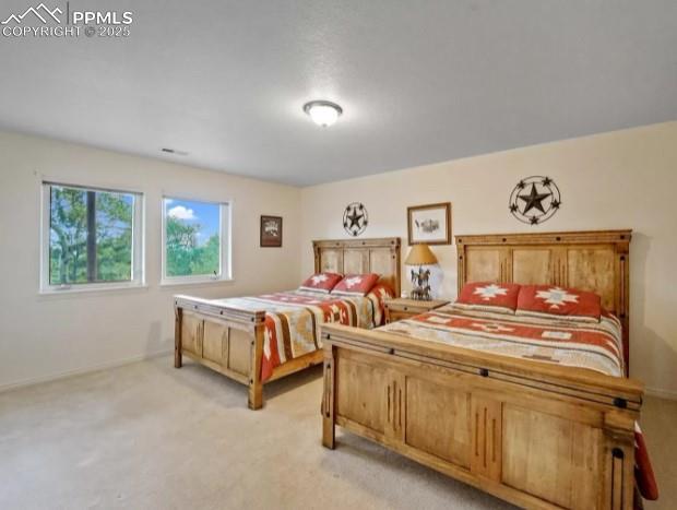 bedroom featuring light colored carpet and baseboards