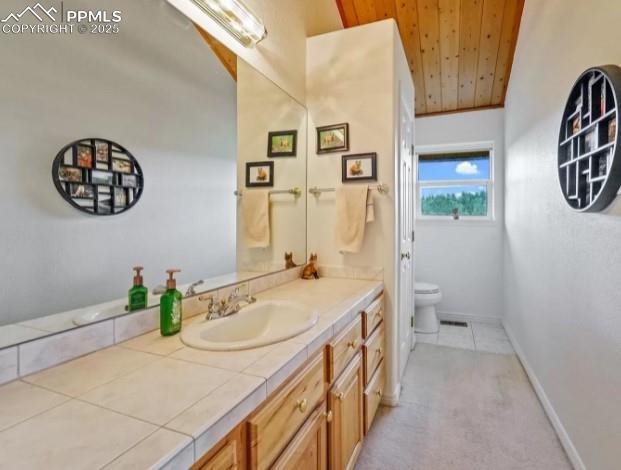 bathroom featuring vanity, baseboards, lofted ceiling, wood ceiling, and toilet