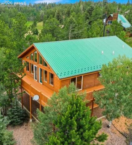 rear view of property featuring a wooded view