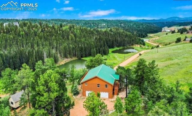 aerial view with a water view and a wooded view