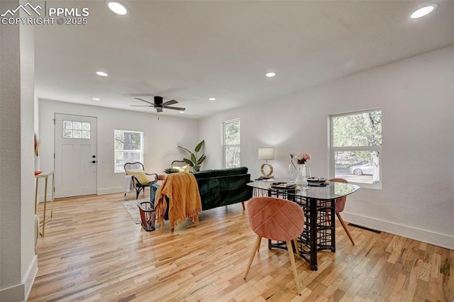 dining space featuring baseboards, light wood-style floors, visible vents, and a healthy amount of sunlight