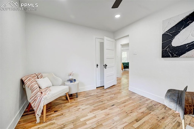 living area with recessed lighting, light wood-style flooring, a ceiling fan, and baseboards