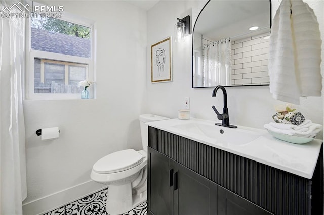 full bathroom with vanity, toilet, and baseboards