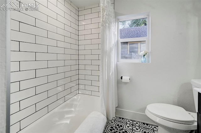 bathroom featuring tile patterned flooring, toilet, and baseboards