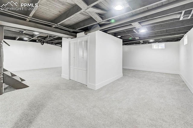 basement featuring baseboards and carpet floors