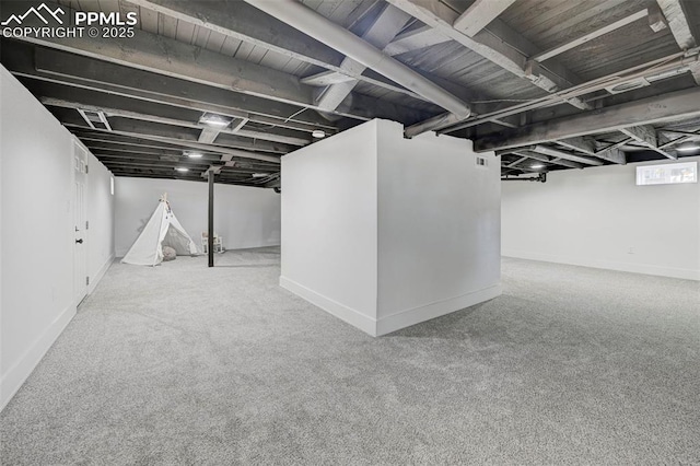 finished basement featuring baseboards and carpet floors