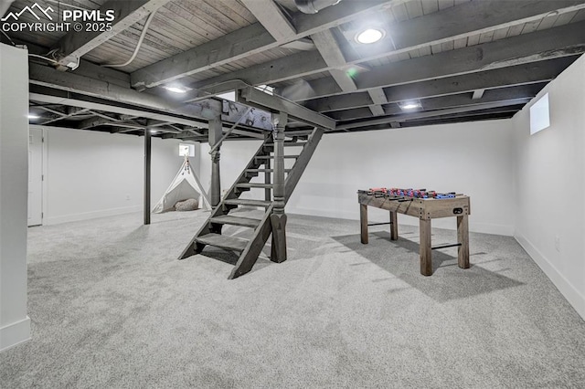 finished basement featuring stairway, carpet, and baseboards