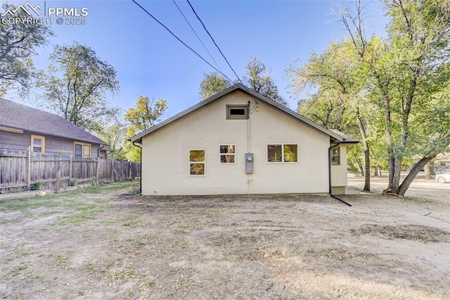 back of property with fence and stucco siding