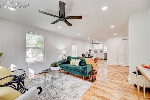 living room featuring recessed lighting, a ceiling fan, light wood-type flooring, and baseboards