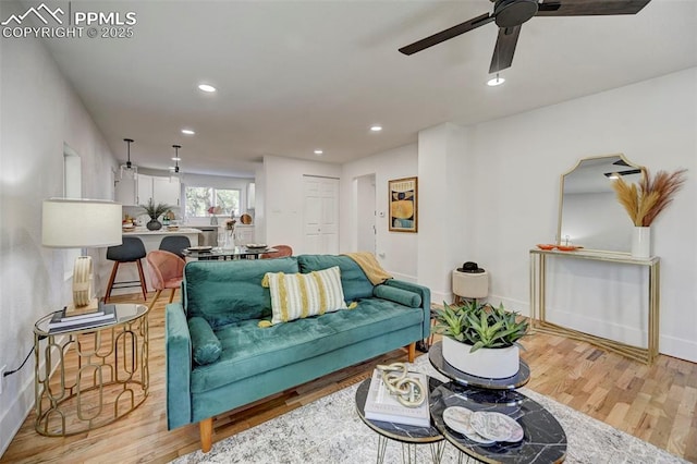 living area with a ceiling fan, recessed lighting, wood finished floors, and baseboards