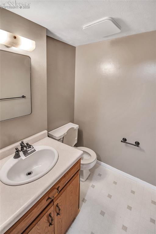 bathroom featuring toilet, tile patterned floors, and vanity