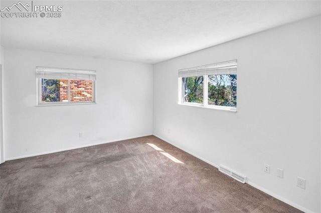 empty room featuring carpet flooring, baseboards, and visible vents