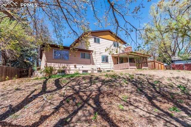 rear view of house featuring fence