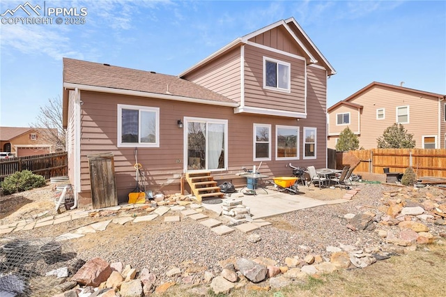 rear view of property with board and batten siding, a fenced backyard, entry steps, and a patio area