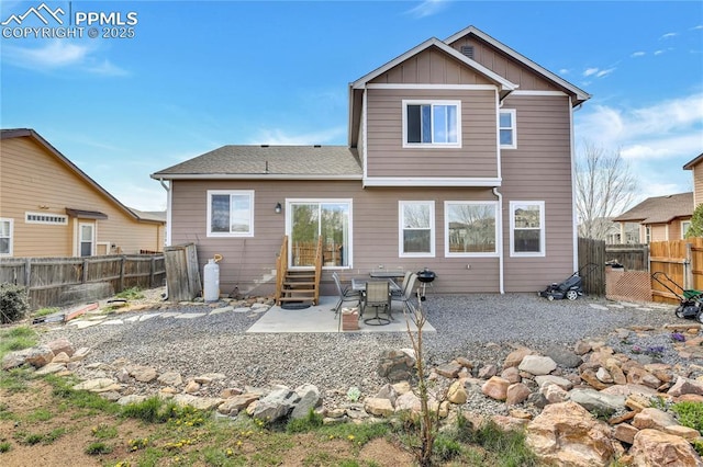 rear view of house featuring entry steps, a patio, board and batten siding, and a fenced backyard