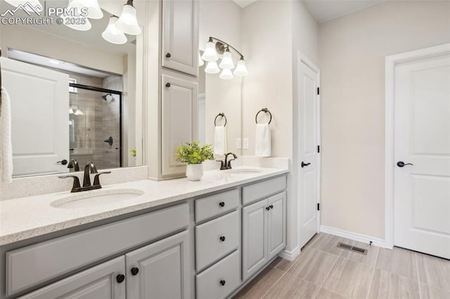 6001 Bennach Grv, Colorado Springs, CO 80927 - bathroom with double vanity, a stall shower, visible vents, and a sink