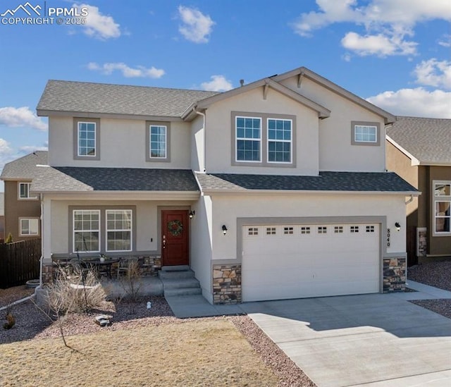 8040 Barraport Dr, Colorado Springs, CO 80908 - view of front of house with stucco siding, an attached garage, stone siding, and concrete driveway