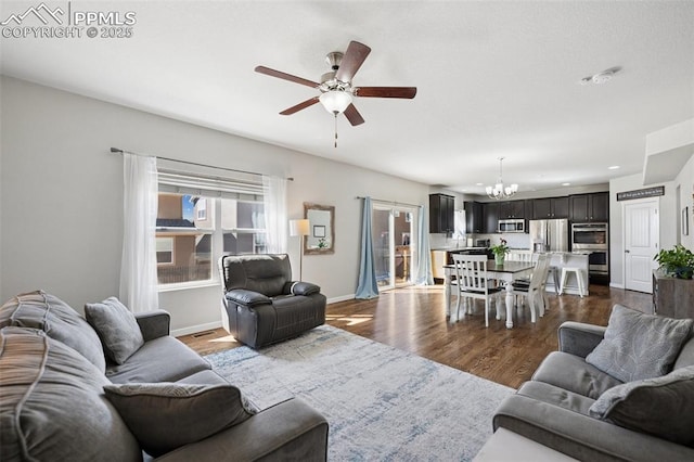 8040 Barraport Dr, Colorado Springs, CO 80908 - living area featuring ceiling fan with notable chandelier, baseboards, and dark wood-style flooring