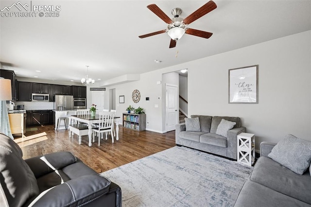 8040 Barraport Dr, Colorado Springs, CO 80908 - living area with ceiling fan with notable chandelier, stairs, baseboards, and dark wood-style floors