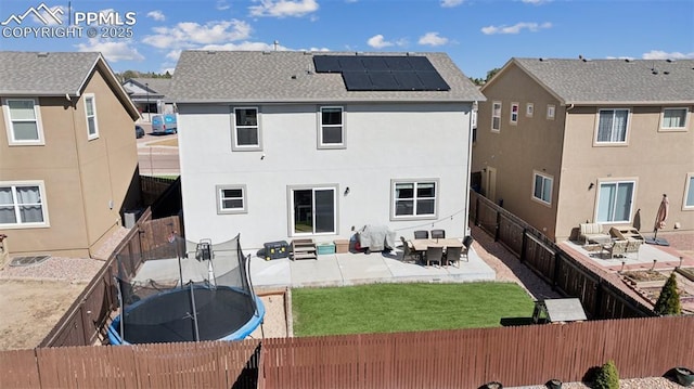 8040 Barraport Dr, Colorado Springs, CO 80908 - back of house featuring a fenced backyard, entry steps, a trampoline, solar panels, and a patio area