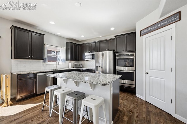 8040 Barraport Dr, Colorado Springs, CO 80908 - kitchen featuring backsplash, dark wood-style flooring, stainless steel appliances, and light stone counters