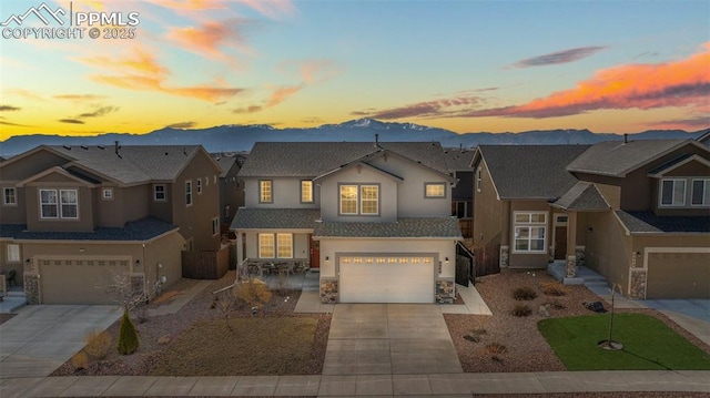 8040 Barraport Dr, Colorado Springs, CO 80908 - view of front of property featuring driveway, stone siding, stucco siding, a residential view, and a garage