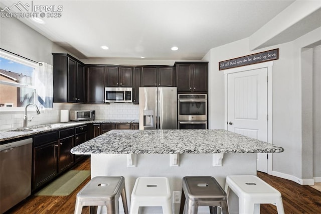 8040 Barraport Dr, Colorado Springs, CO 80908 - kitchen featuring dark wood-style floors, decorative backsplash, a sink, and stainless steel appliances
