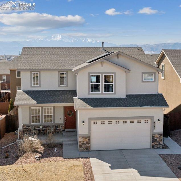 8040 Barraport Dr, Colorado Springs, CO 80908 - traditional-style home featuring stone siding, driveway, an attached garage, roof with shingles, and stucco siding