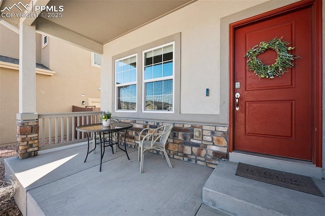 8040 Barraport Dr, Colorado Springs, CO 80908 - doorway to property with stone siding, a porch, and stucco siding