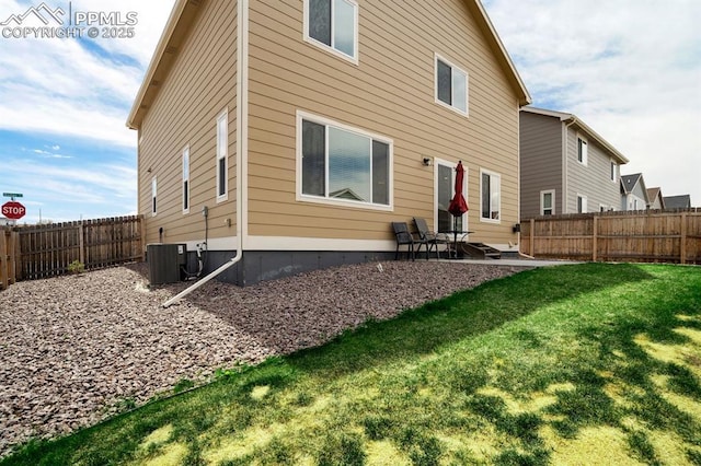 rear view of house with central AC, a patio area, a yard, and a fenced backyard