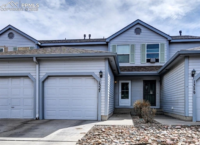 view of front facade with an attached garage, driveway, and roof with shingles
