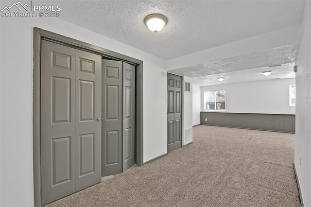 interior space featuring visible vents, carpet floors, and a textured ceiling