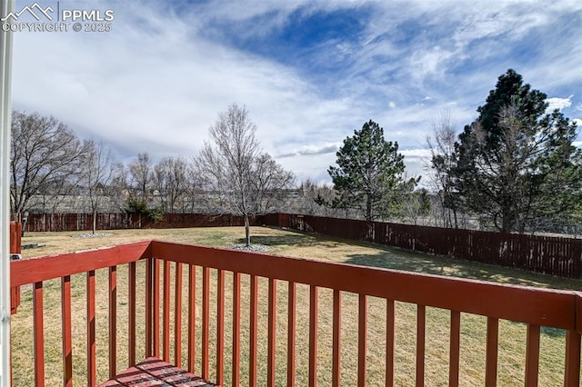 deck with a yard and a fenced backyard