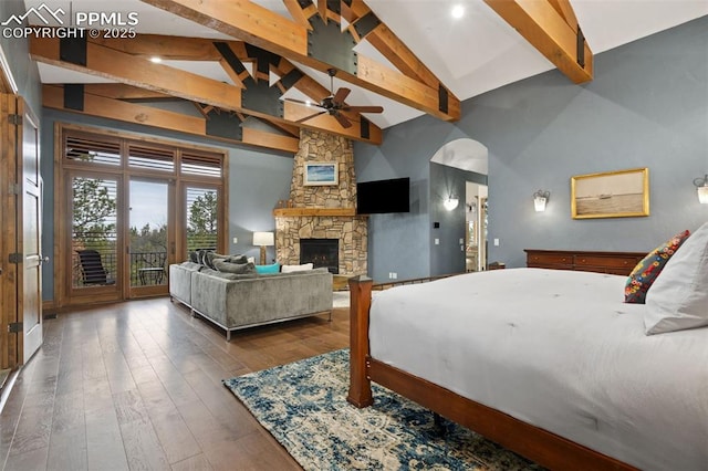 bedroom featuring high vaulted ceiling, access to outside, hardwood / wood-style flooring, beamed ceiling, and a stone fireplace