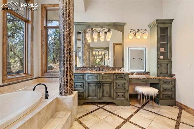 bathroom featuring a chandelier, vanity, baseboards, and a garden tub