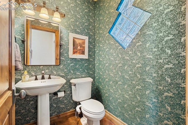 bathroom with baseboards and toilet