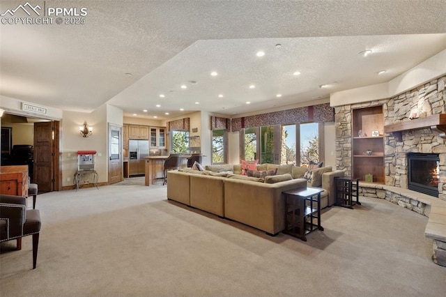 living area featuring a textured ceiling, a stone fireplace, light colored carpet, visible vents, and recessed lighting