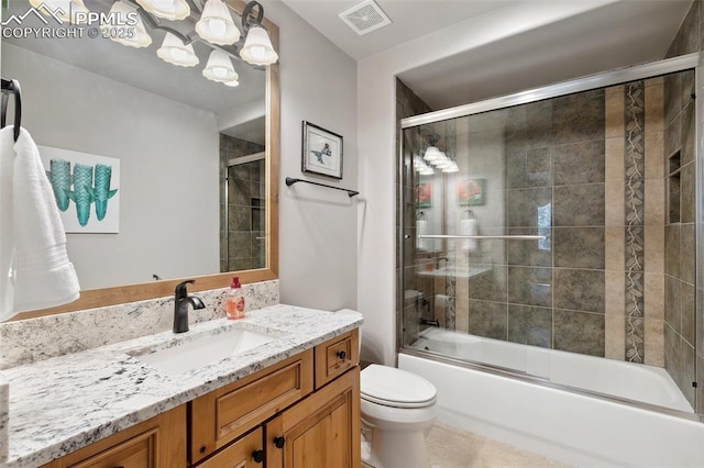 full bath featuring visible vents, toilet, vanity, and shower / bath combination with glass door