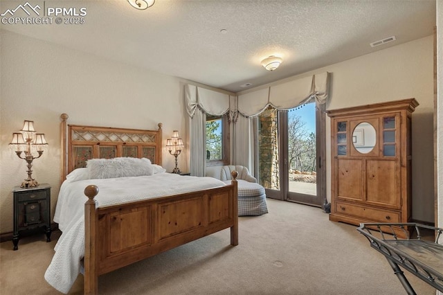 bedroom with access to exterior, light colored carpet, visible vents, and a textured ceiling