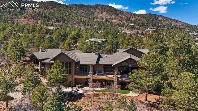 birds eye view of property featuring a wooded view and a mountain view