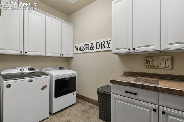 laundry area with independent washer and dryer, visible vents, cabinet space, and baseboards