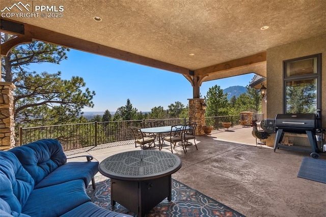view of patio featuring outdoor dining space, area for grilling, and a mountain view