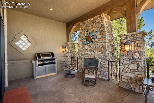 view of patio featuring exterior kitchen and an outdoor stone fireplace