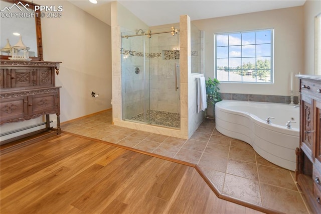 266 University Dr, Woodland Park, CO 80863 - bathroom featuring baseboards, a stall shower, wood finished floors, a bath, and vanity