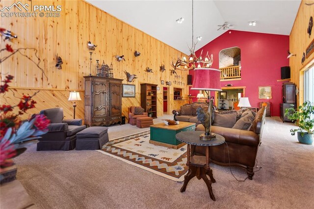 266 University Dr, Woodland Park, CO 80863 - carpeted living room with a ceiling fan, wood walls, and high vaulted ceiling