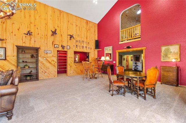 266 University Dr, Woodland Park, CO 80863 - carpeted dining space with wooden walls and high vaulted ceiling