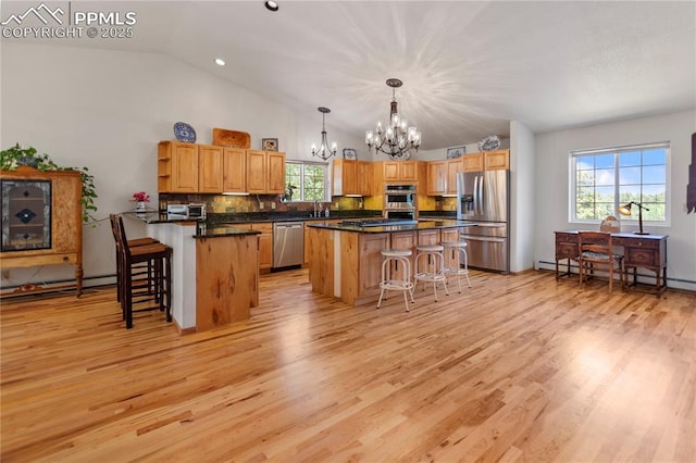 266 University Dr, Woodland Park, CO 80863 - kitchen featuring dark countertops, a kitchen bar, baseboard heating, an inviting chandelier, and stainless steel appliances